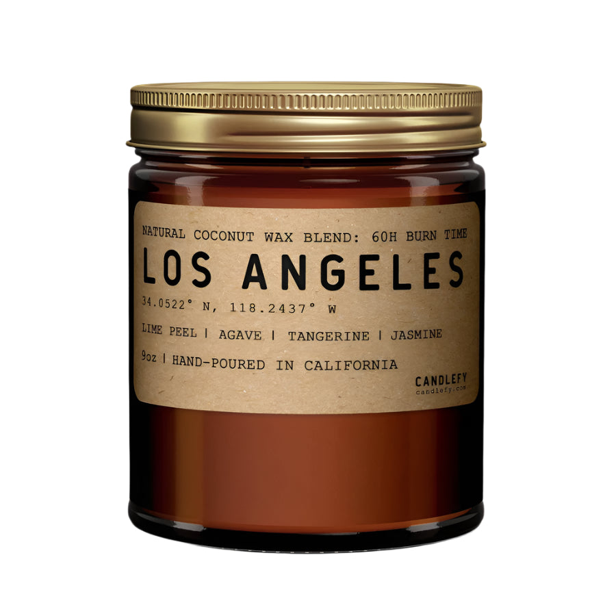 An 8 oz amber glass jar candle with a golden brass lid, labeled 'LOS ANGELES' and scented with citrusy lime peel and tangerine, balanced with jasmine and agave notes.