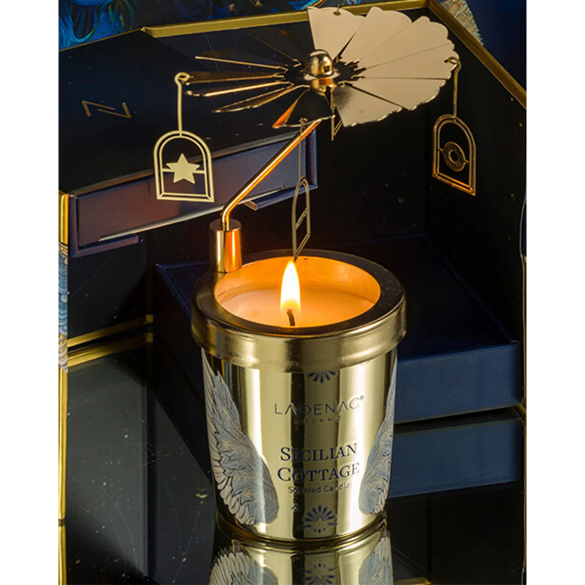 Gold candle holder with a lit candle inside, featuring the brand &#39;Ladenac&#39;.