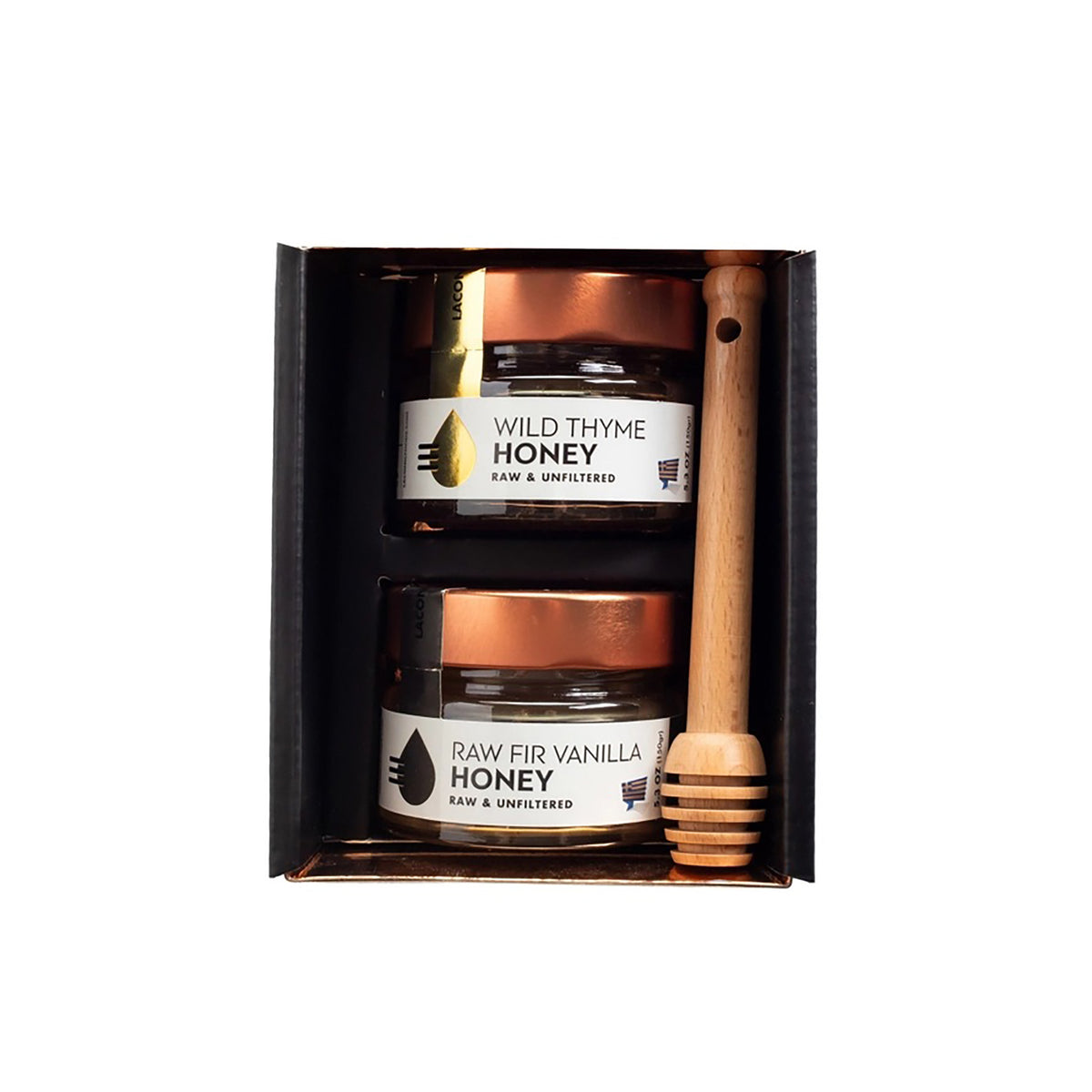 A gift set of two honey jars and a wooden honey dipper in a black presentation box. The top jar is labeled 'WILD THYME HONEY' and the bottom jar is labeled 'RAW FIR VANILLA HONEY'.