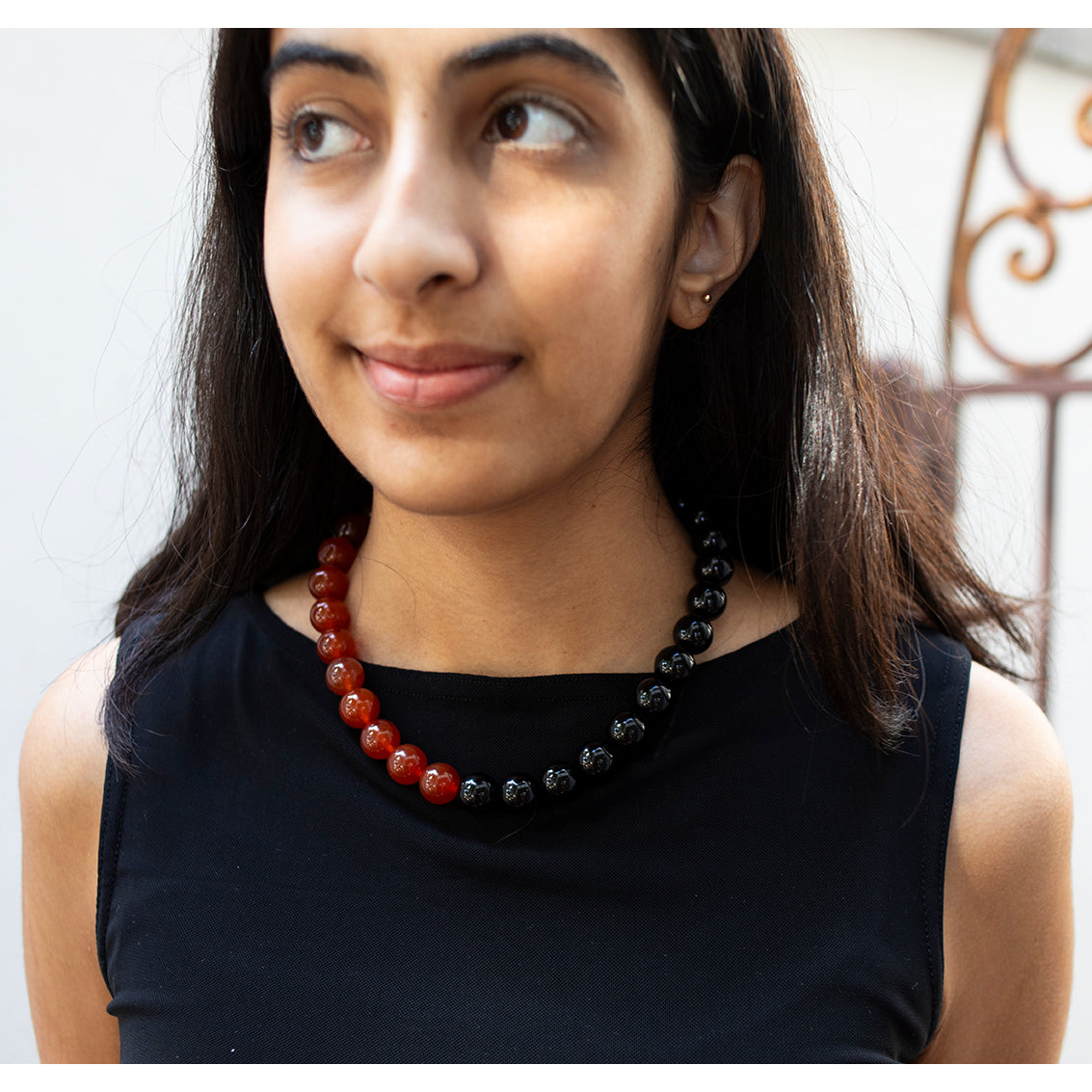 A choker necklace featuring alternating large onyx beads and carnelian beads with a magnetic clasp.