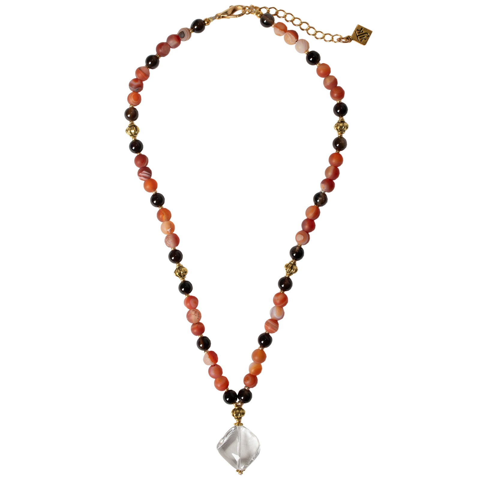 A necklace featuring a clear rock crystal pendant with carnelian and agate beads, with gold plated brass accents.