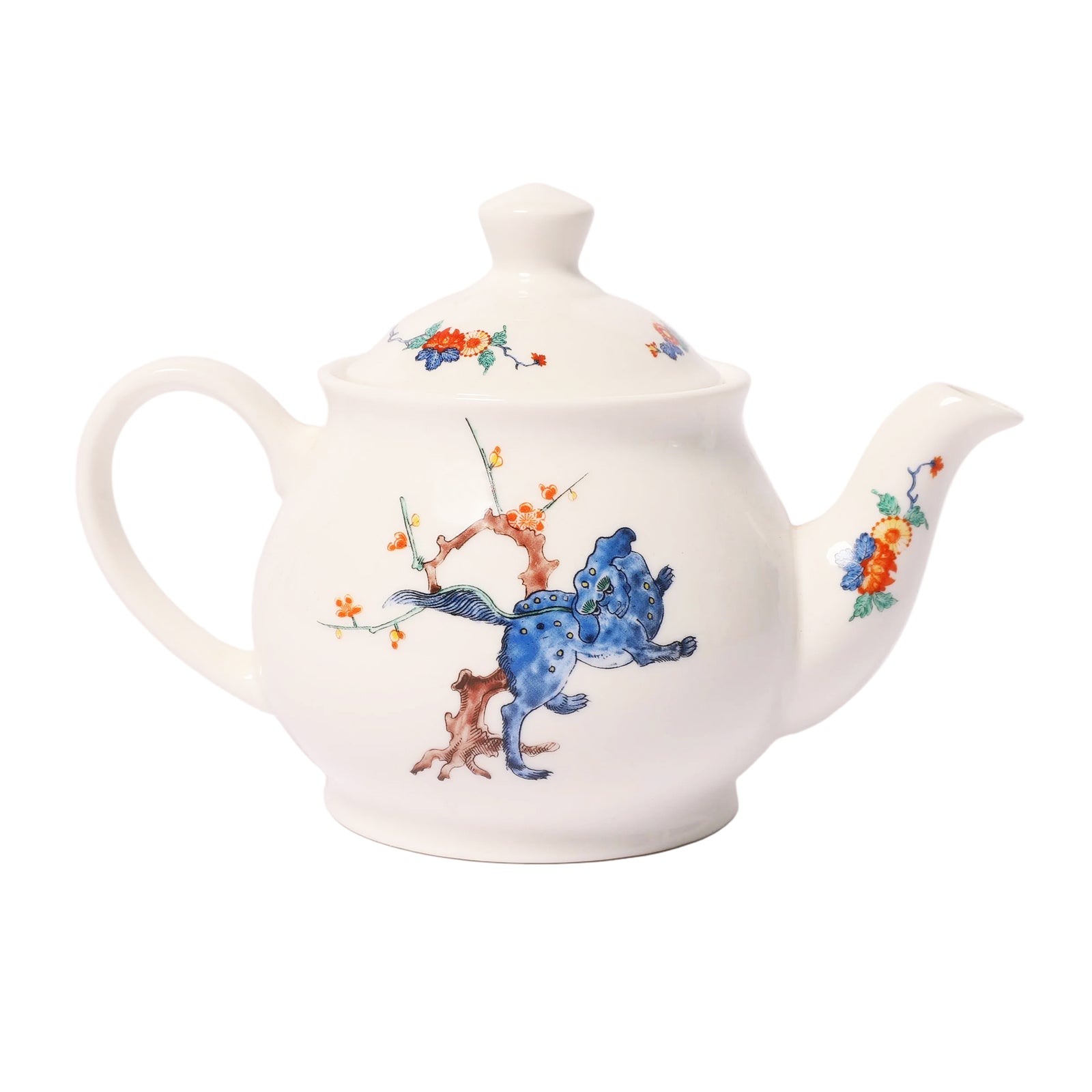 A white ceramic teapot with a lid, decorated with a hand-painted blue cat climbing a brown tree branch with small orange and red flowers, shown on a plain white background.