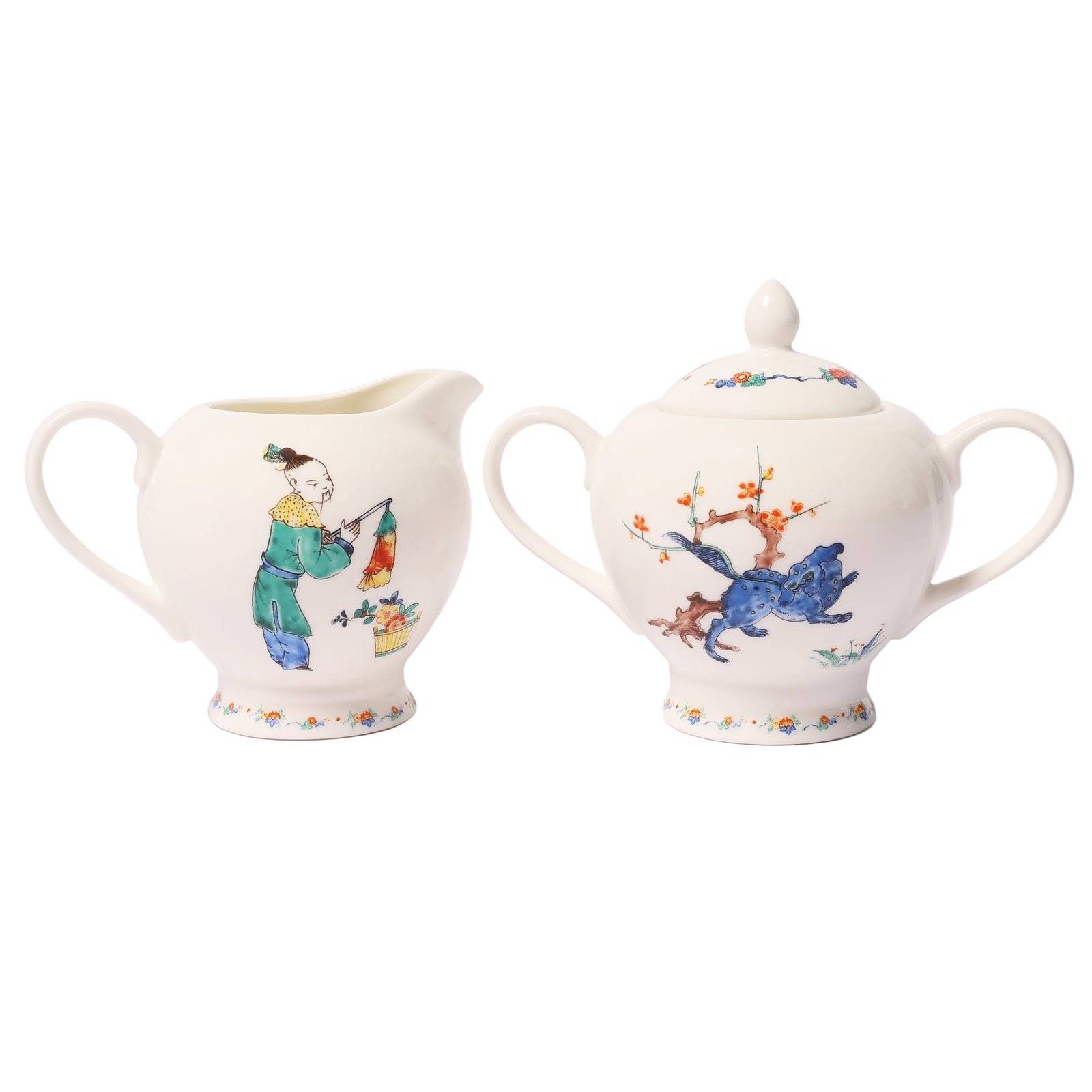 A white porcelain creamer and matching sugar bowl set with hand-painted traditional Chinese-style illustrations, shown on a plain white background.