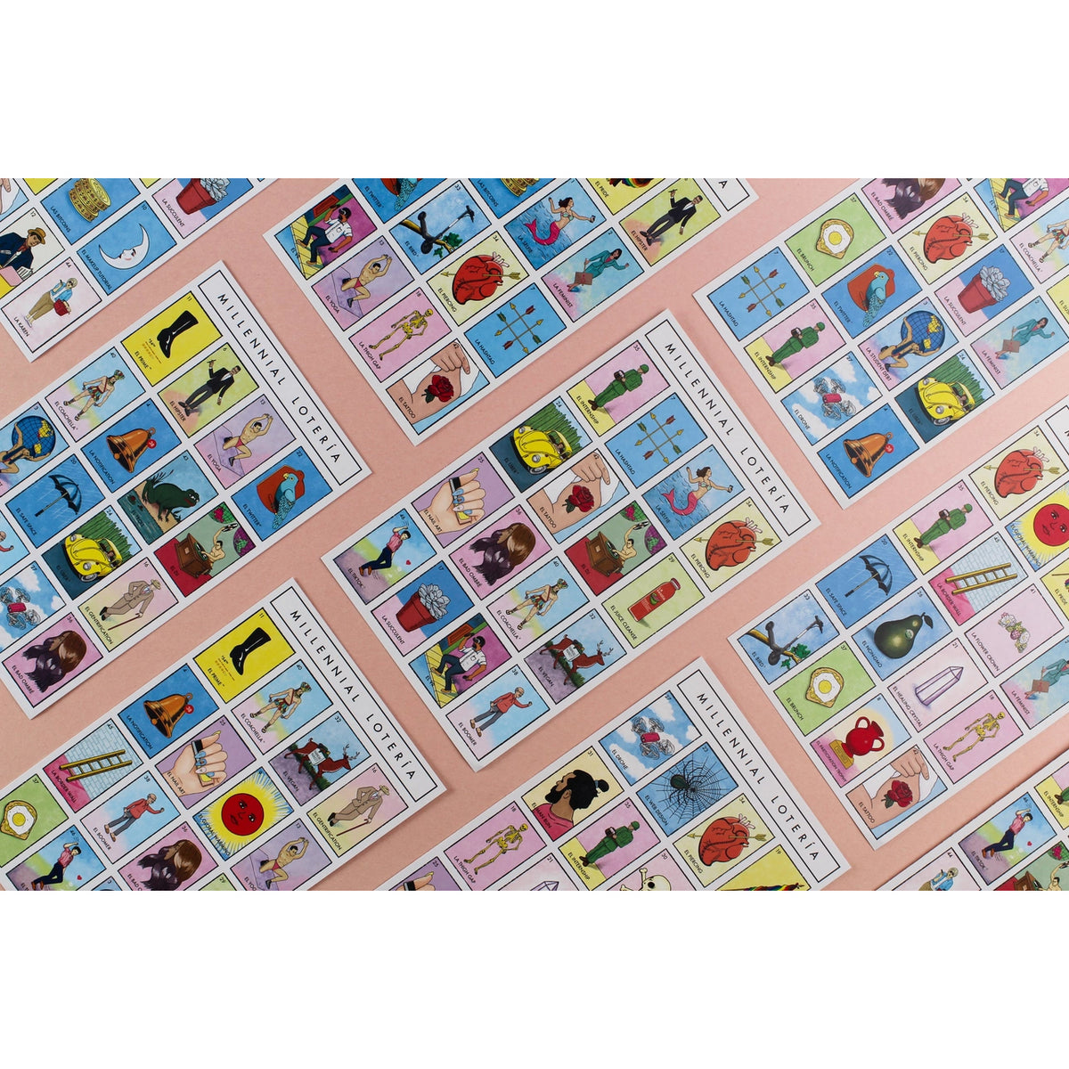 A close-up of multiple overlapping Spanish 'Libro de la Vida' tarot card sheets on a light pink background, showing colorful illustrated cards with traditional symbols and figures.