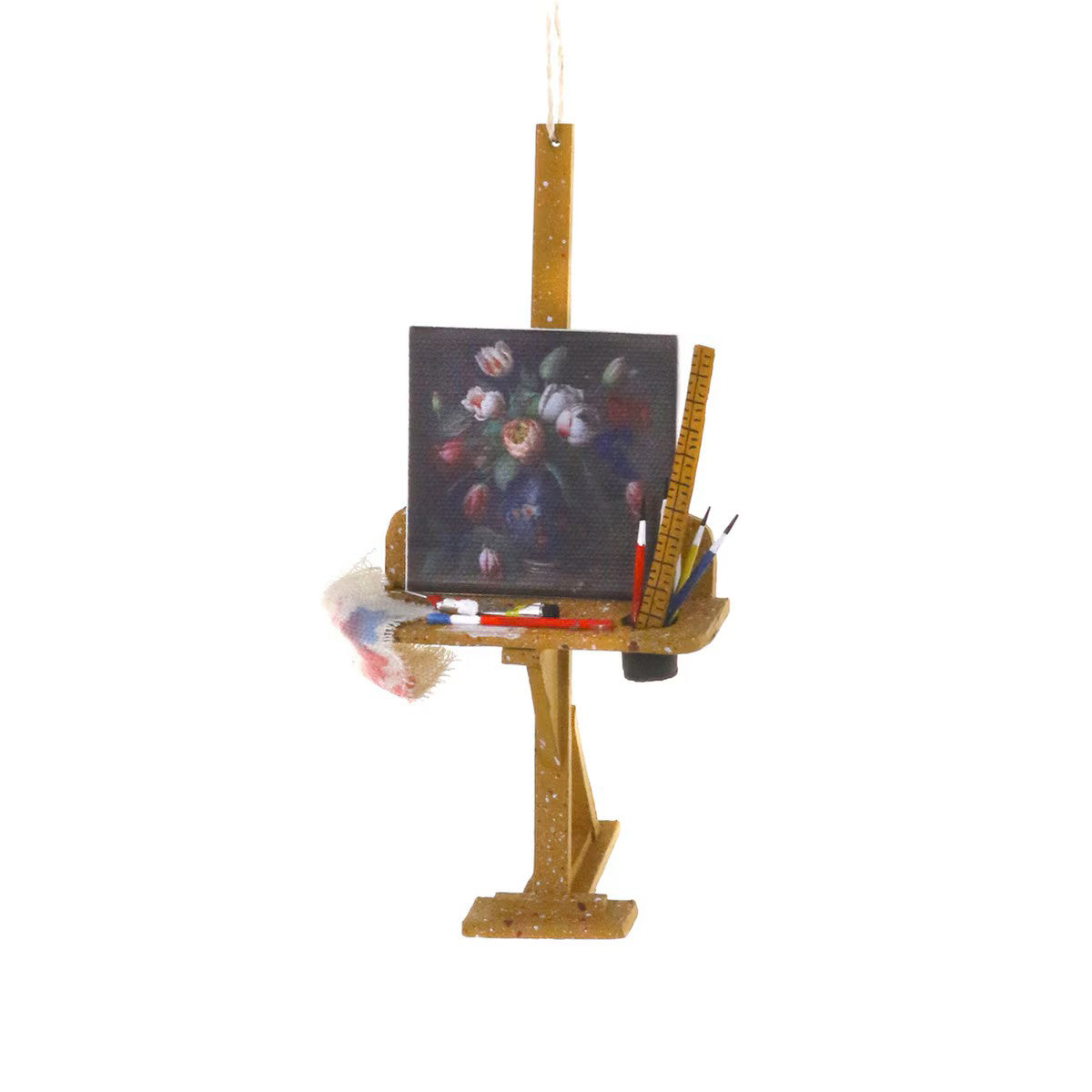 Miniature artist's easel with a painting and art supplies on a white background