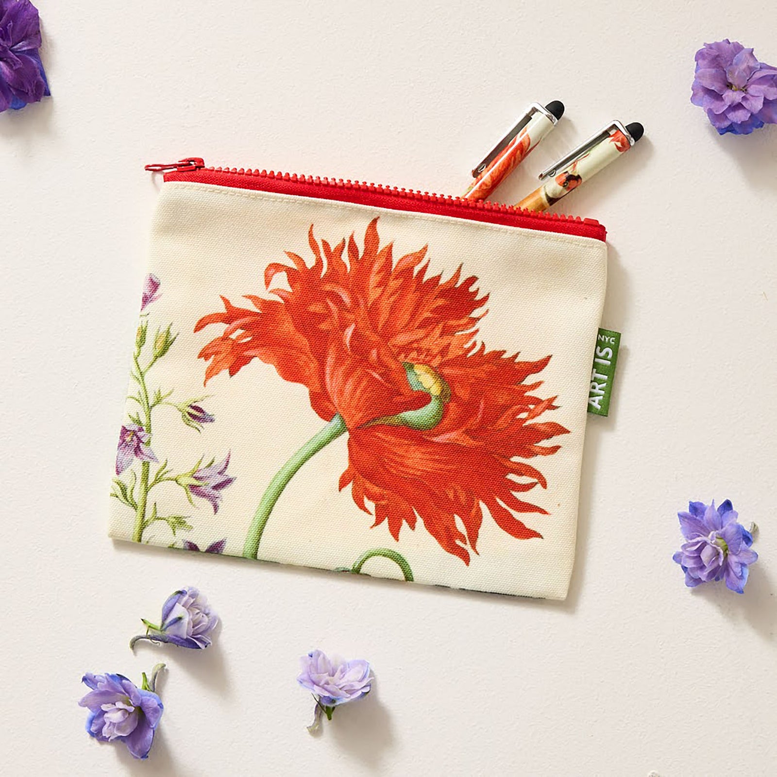 A zip pouch featuring a botanical illustration with a bird and plants on a white background, with a red zipper.