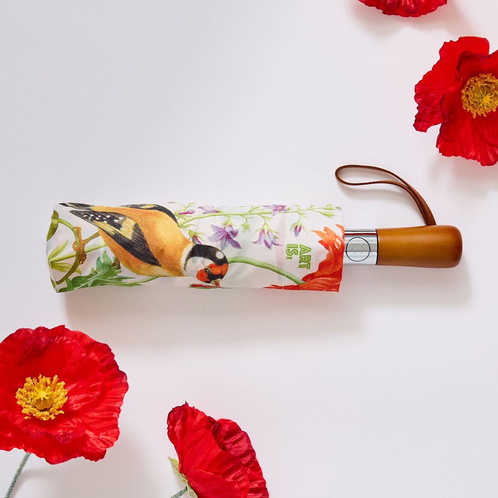 A decorative umbrella with a printed design featuring two birds on a white background, with a wooden handle and red detailing.