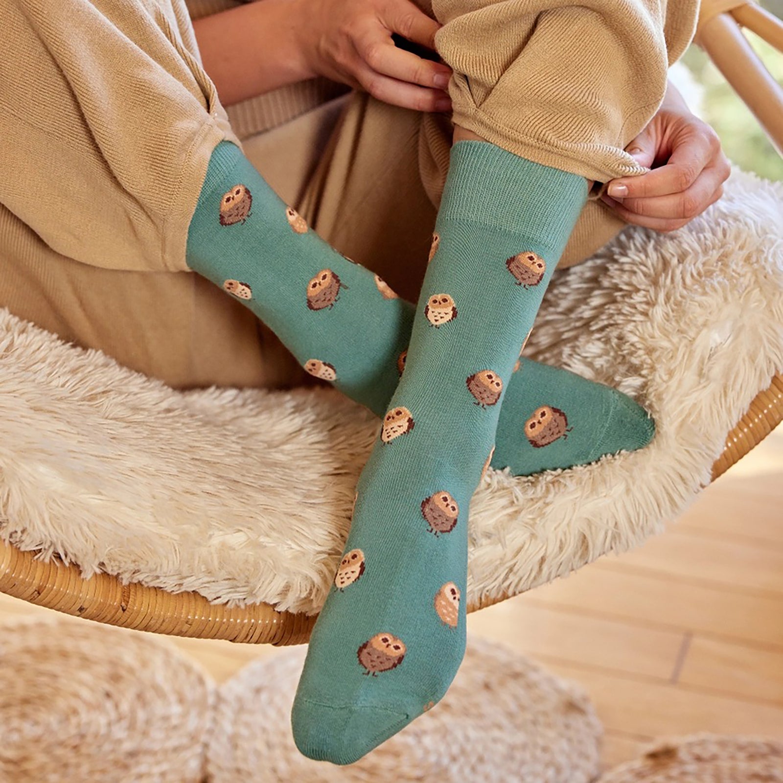 Green sock with owl pattern on a white background