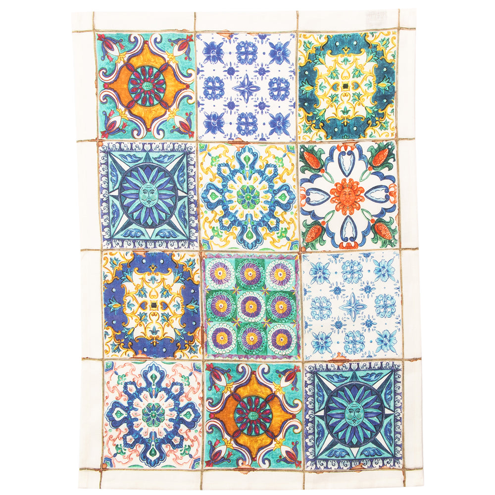 A tea towel featuring a collection of square Italian tiles with various floral and geometric patterns in a variety of colors including blue, green, yellow, and white.
