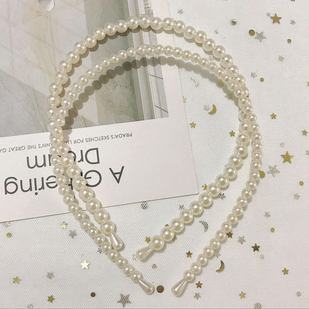 Pearl hairband on a light background with decorative elements
