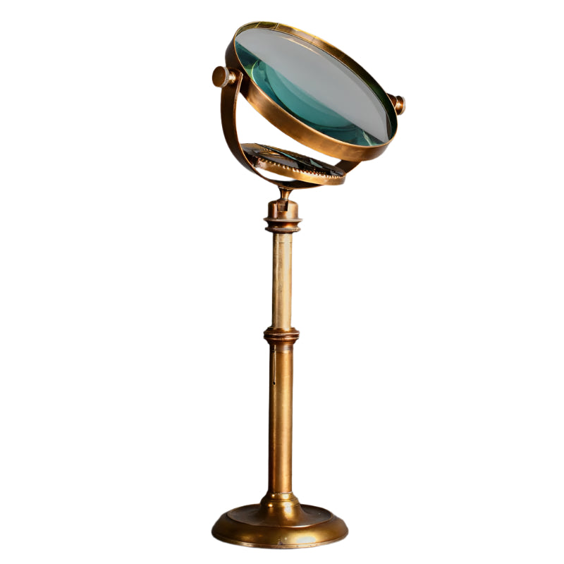 A 19th-century style entomologist's magnifying glass with a brass and glass construction, featuring a gilded finish and a telescopic stand on a white background