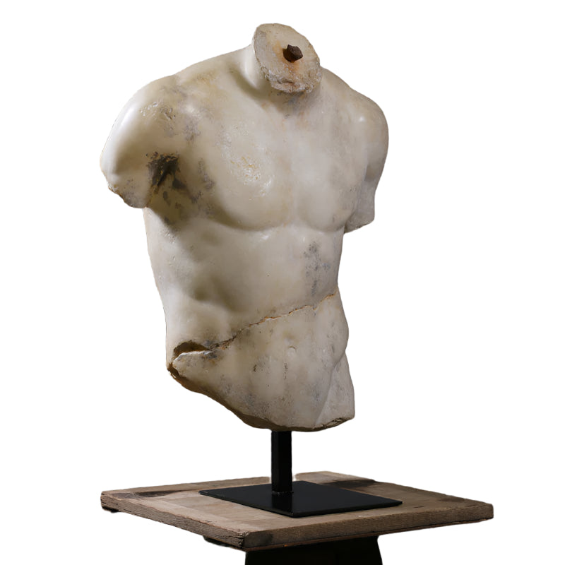 A sculpture of a torso made of alabaster and other composite materials, displayed on a stand.