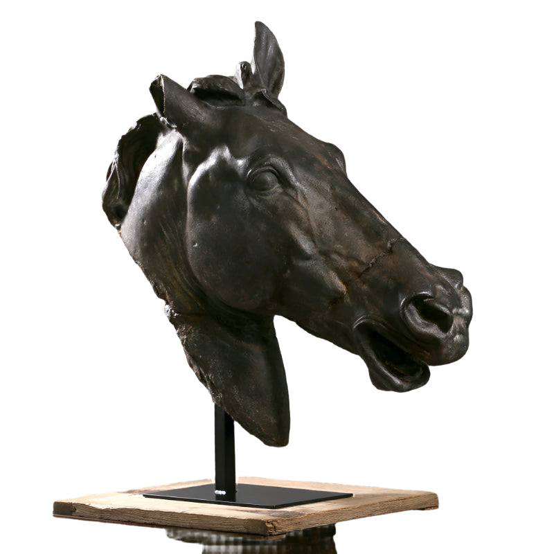 A bronze sculpture of a horse's head on a wooden base with a metal stand.