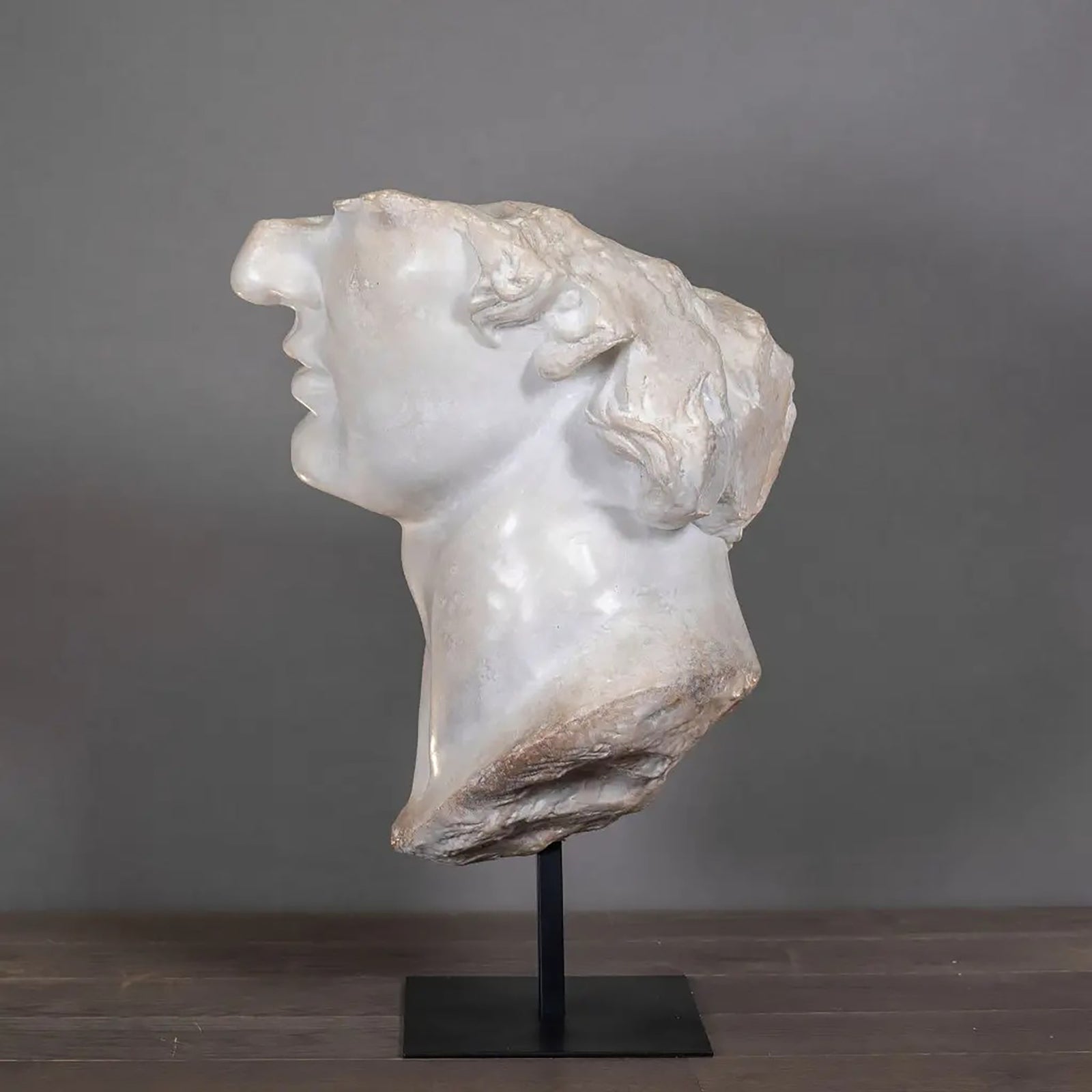 Marble bust on a stand against a white background