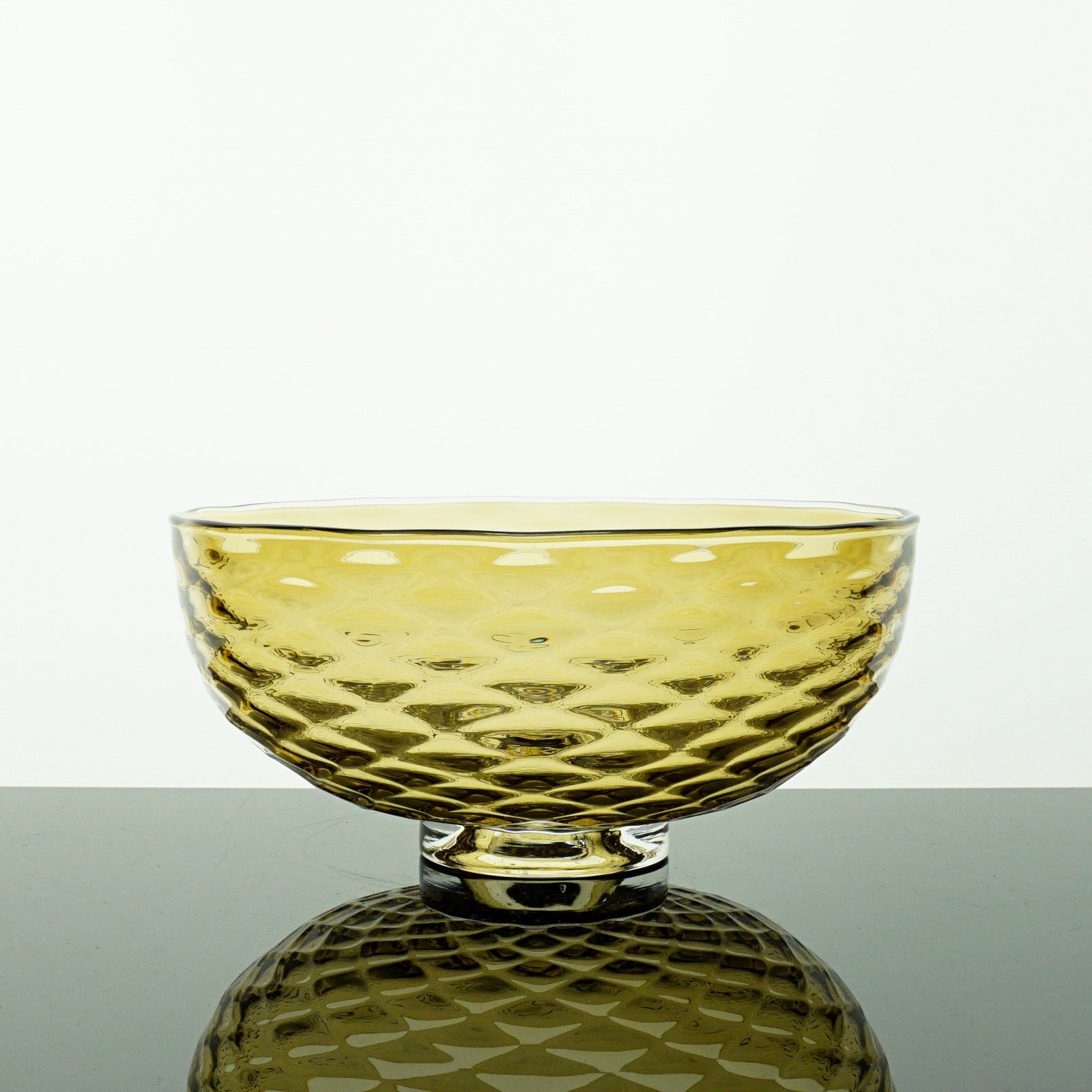 Bronze color glass bowl with textured surface on a white background