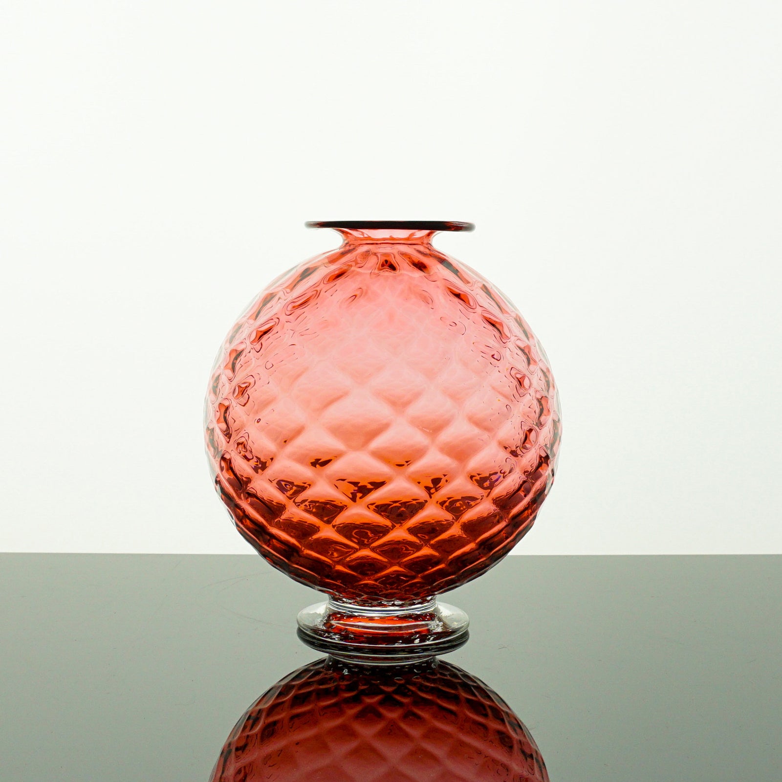 Pink textured glass vase on a white background