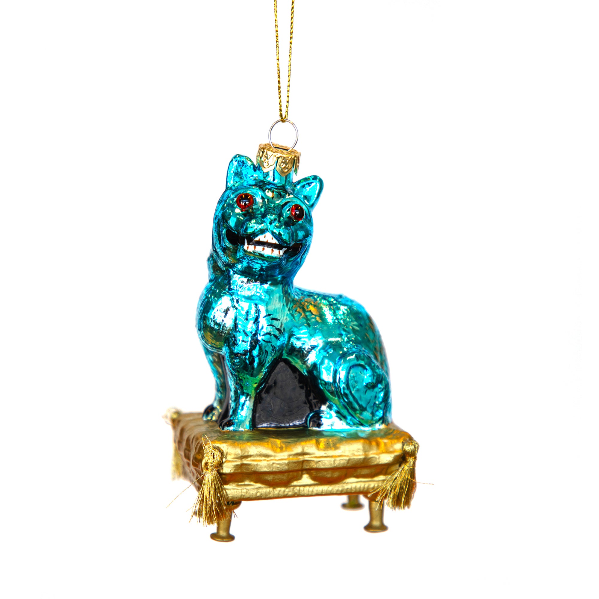 Blue glass cat ornament on a gold pedestal with red eyes against a white background