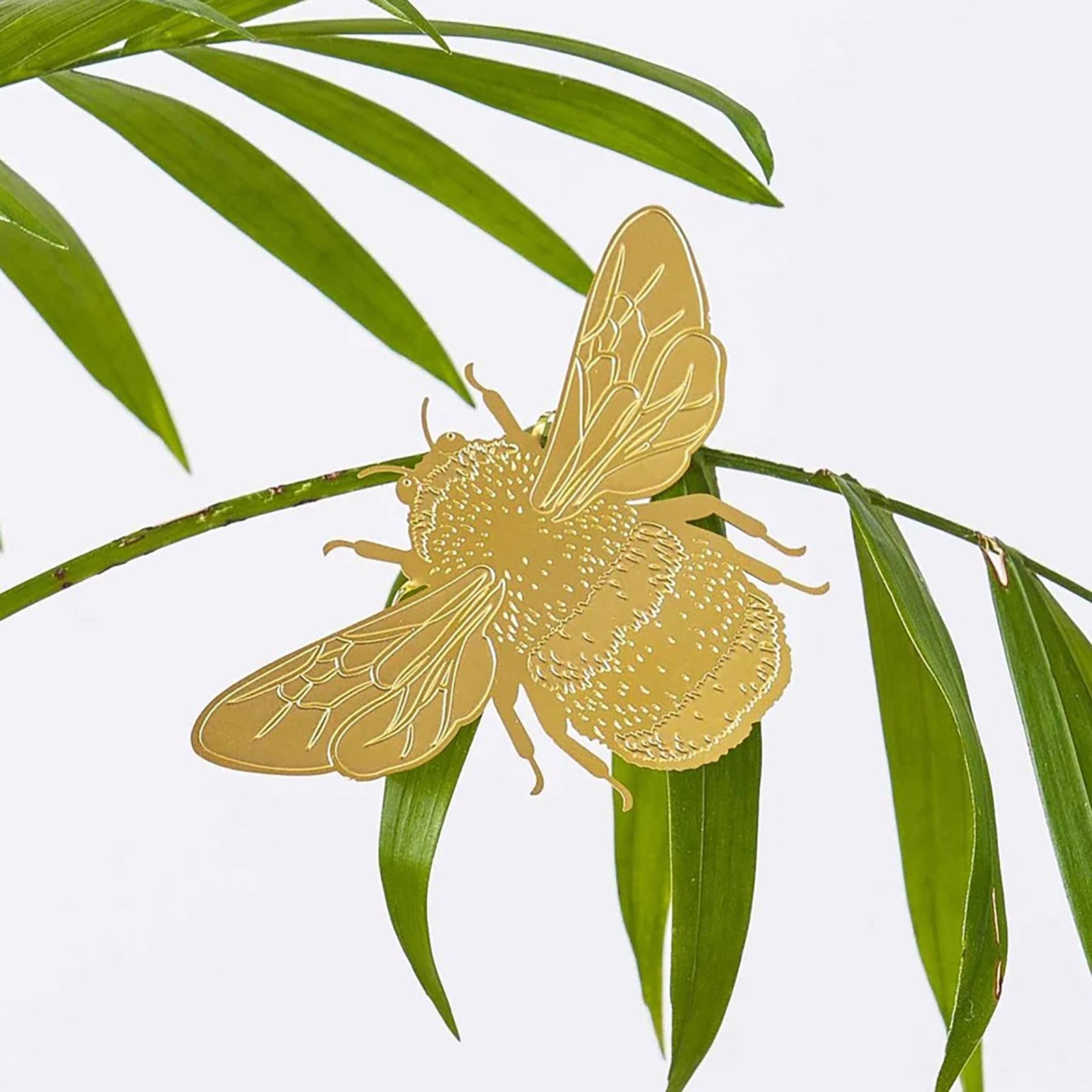 A brass bumblebee ornament designed for attachment to plants, packaged in a green and pink box with 'Plant Animals' branding.