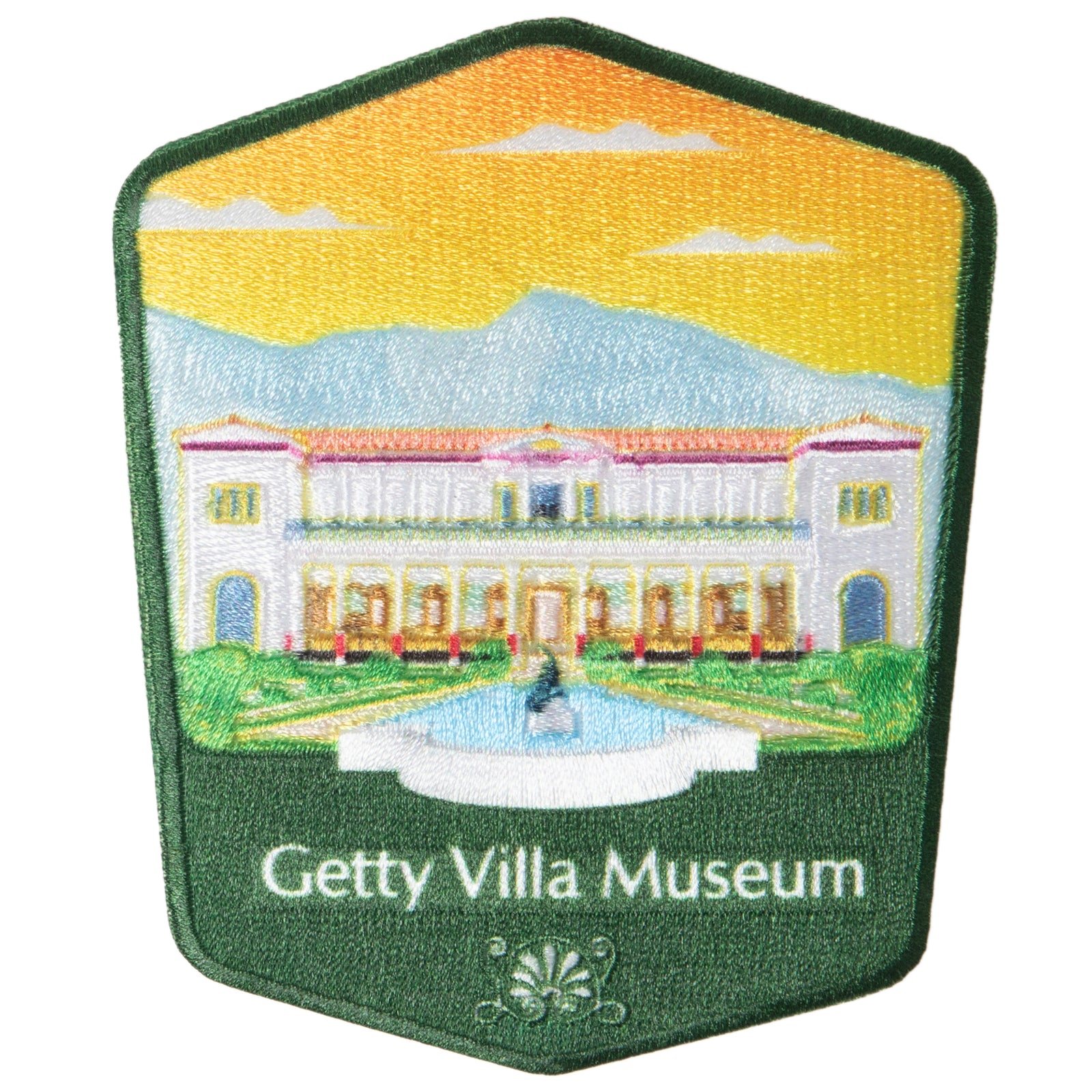 A patch depicting the Getty Villa Museum with a embroidered landscape and building illustration.