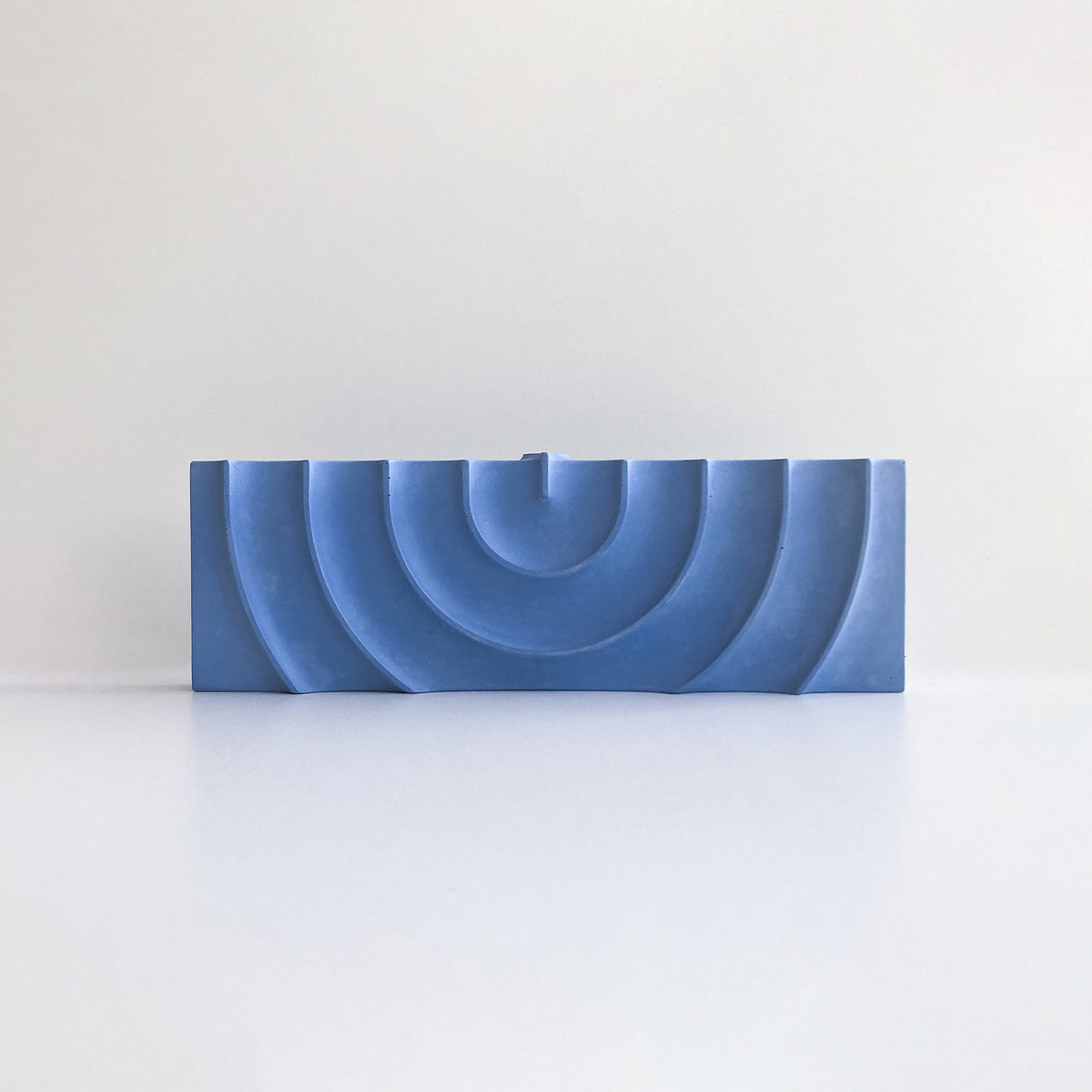 Blue rectangular object with concentric circular patterns on a white background