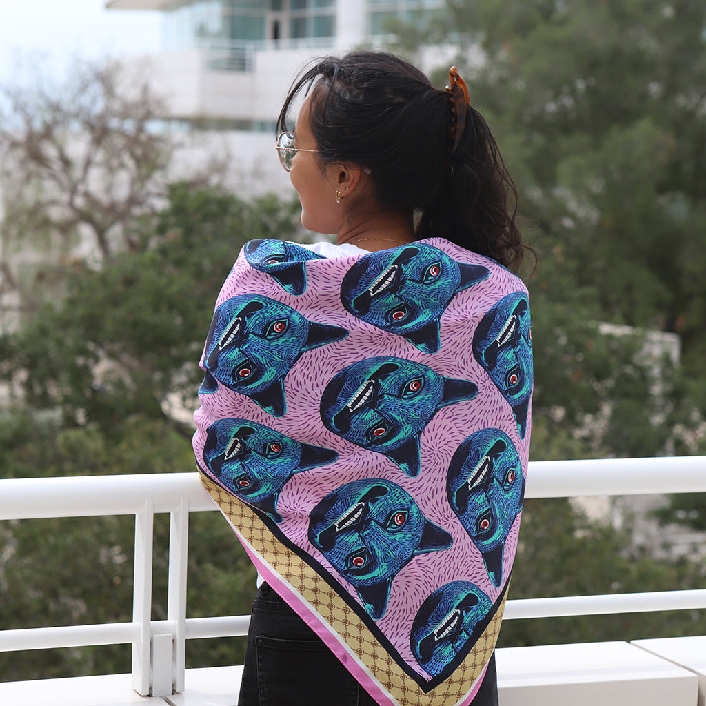 Person wearing a colorful patterned shawl with a blurred outdoor background