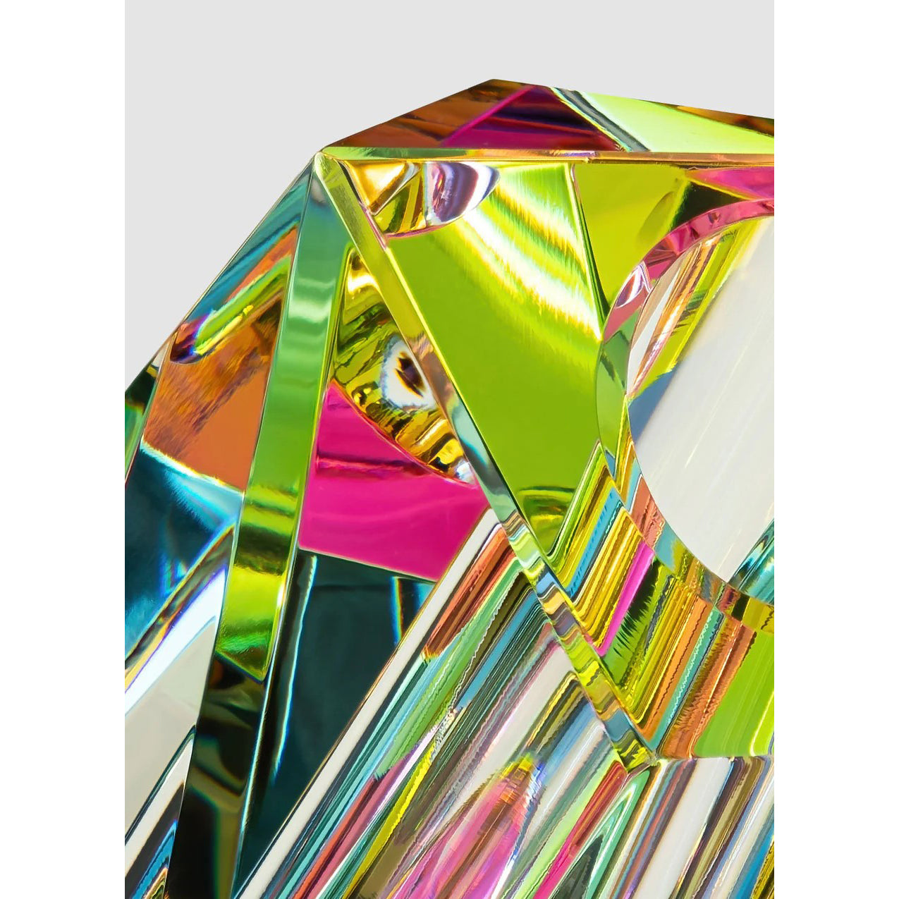A multicolored, angular, hand-cut crystal vase with a dichroic film creating a rainbow effect.