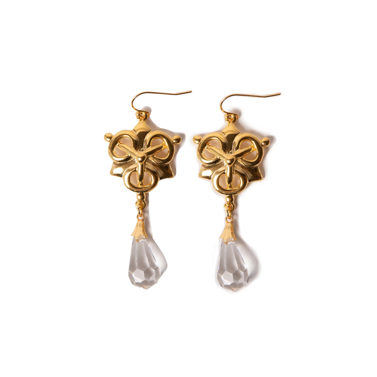Gold earrings with pearl-like droplets on a white background