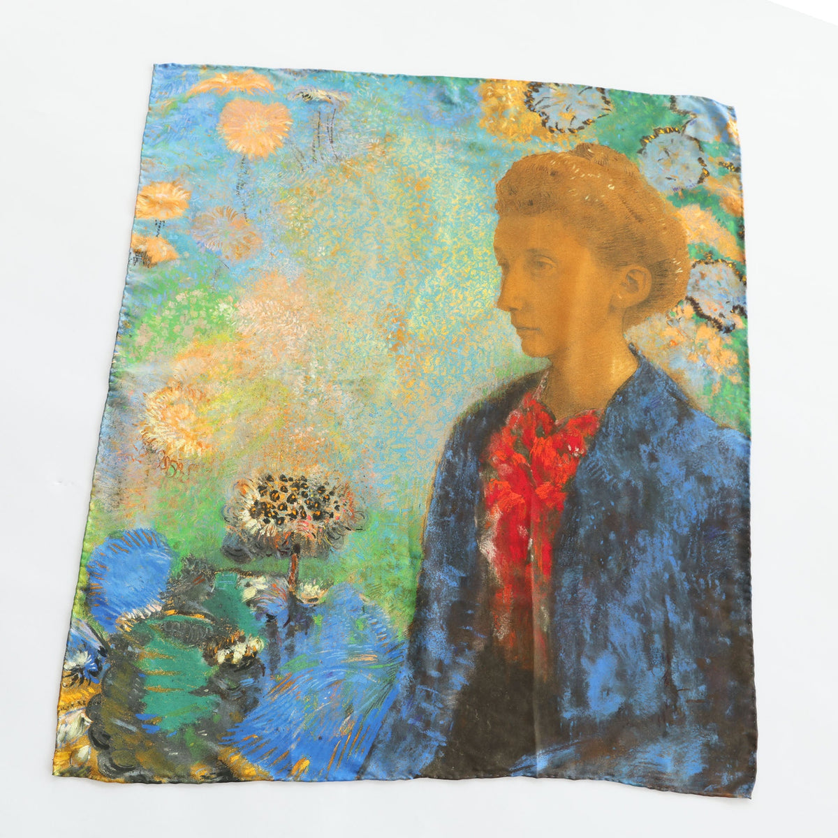 A square scarf featuring an impressionistic painting of a woman in profile, with a blue jacket, red shirt, and a green and gold floral background, displayed flat on a white surface.