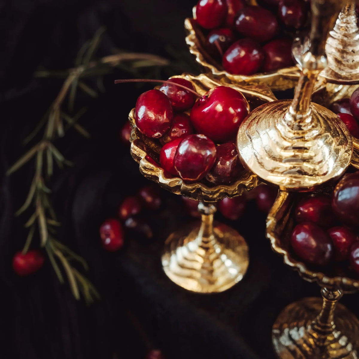 Gold cups with red berries on a dark background