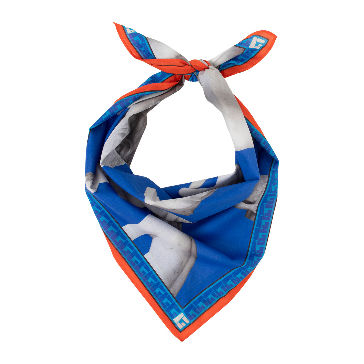 A silk scarf tied in a knot, featuring a blue and white horse print with a bright orange border and a blue Greek key pattern.