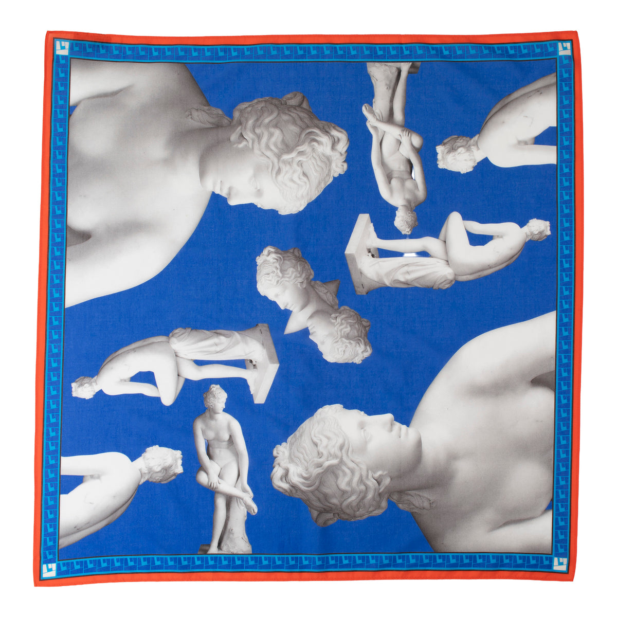 A square silk scarf featuring a classical print of white marble statues of female figures against a vibrant blue background, framed by a red border and a blue patterned inner border.