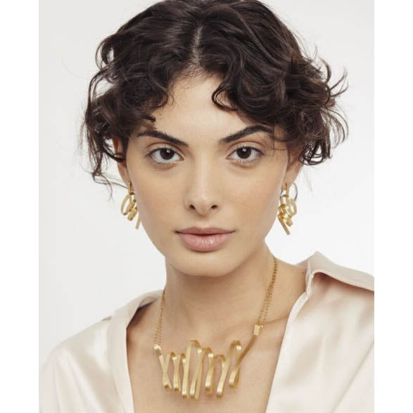 Woman wearing a matching gold necklace and earrings