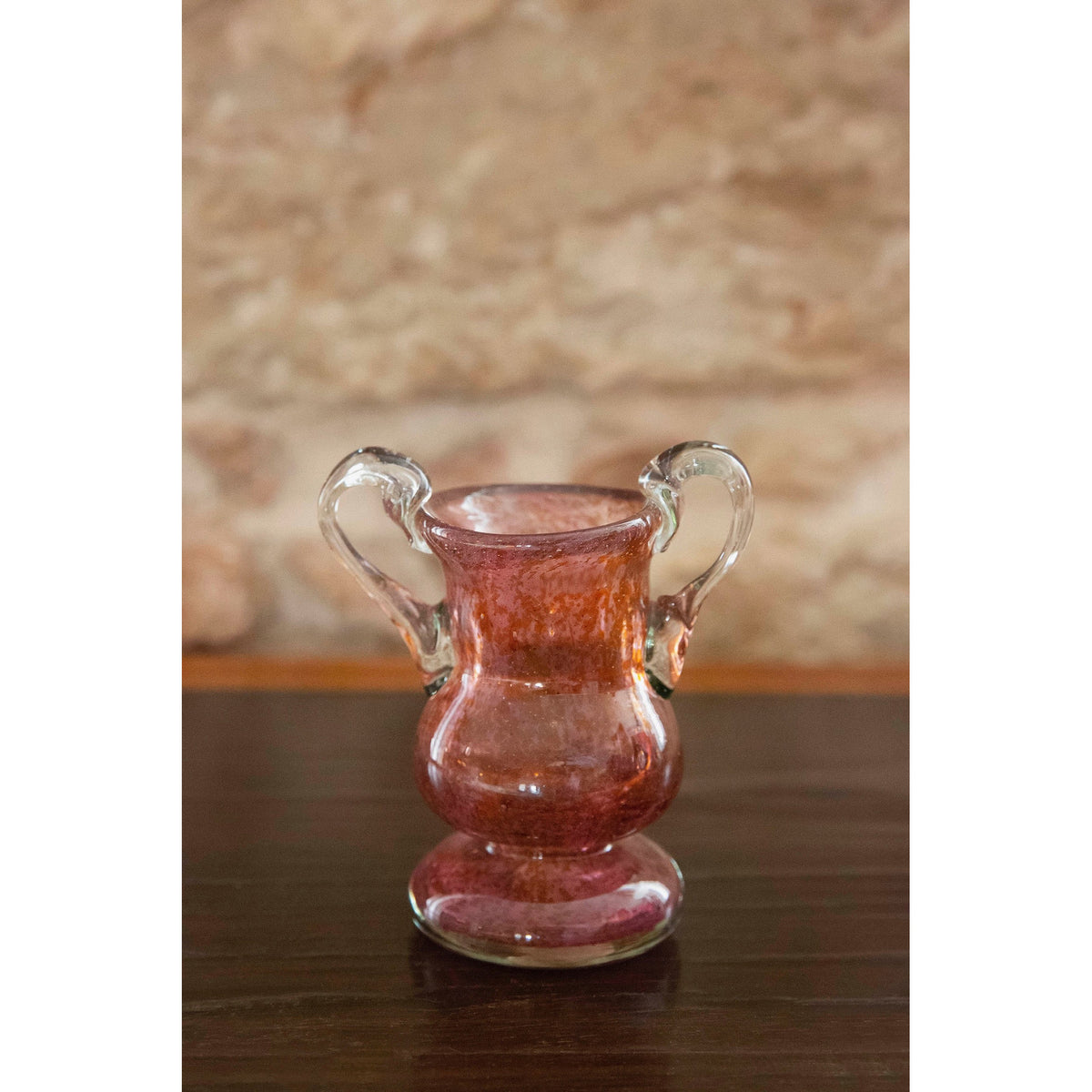 Rose glass vase on wooden background
