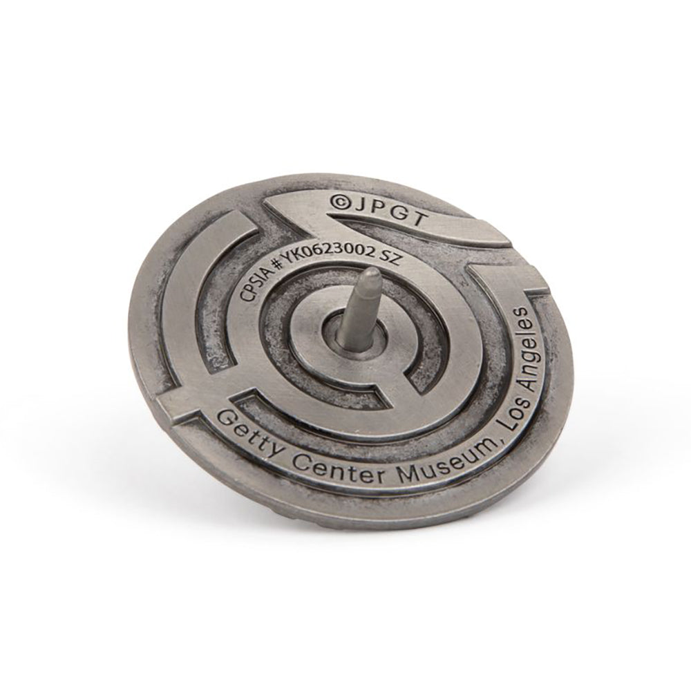 A silver finish metal spinning top with an embossed maze pattern.