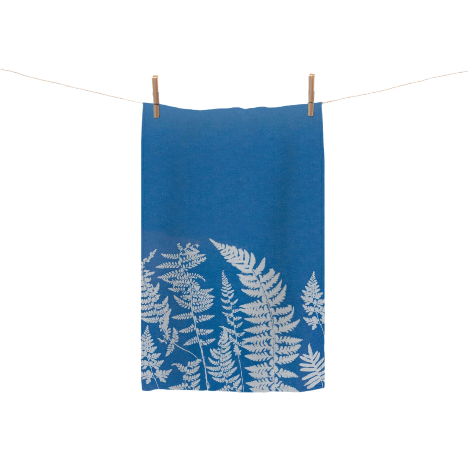A blue tea towel with a white leaf pattern hanging on a clothesline.