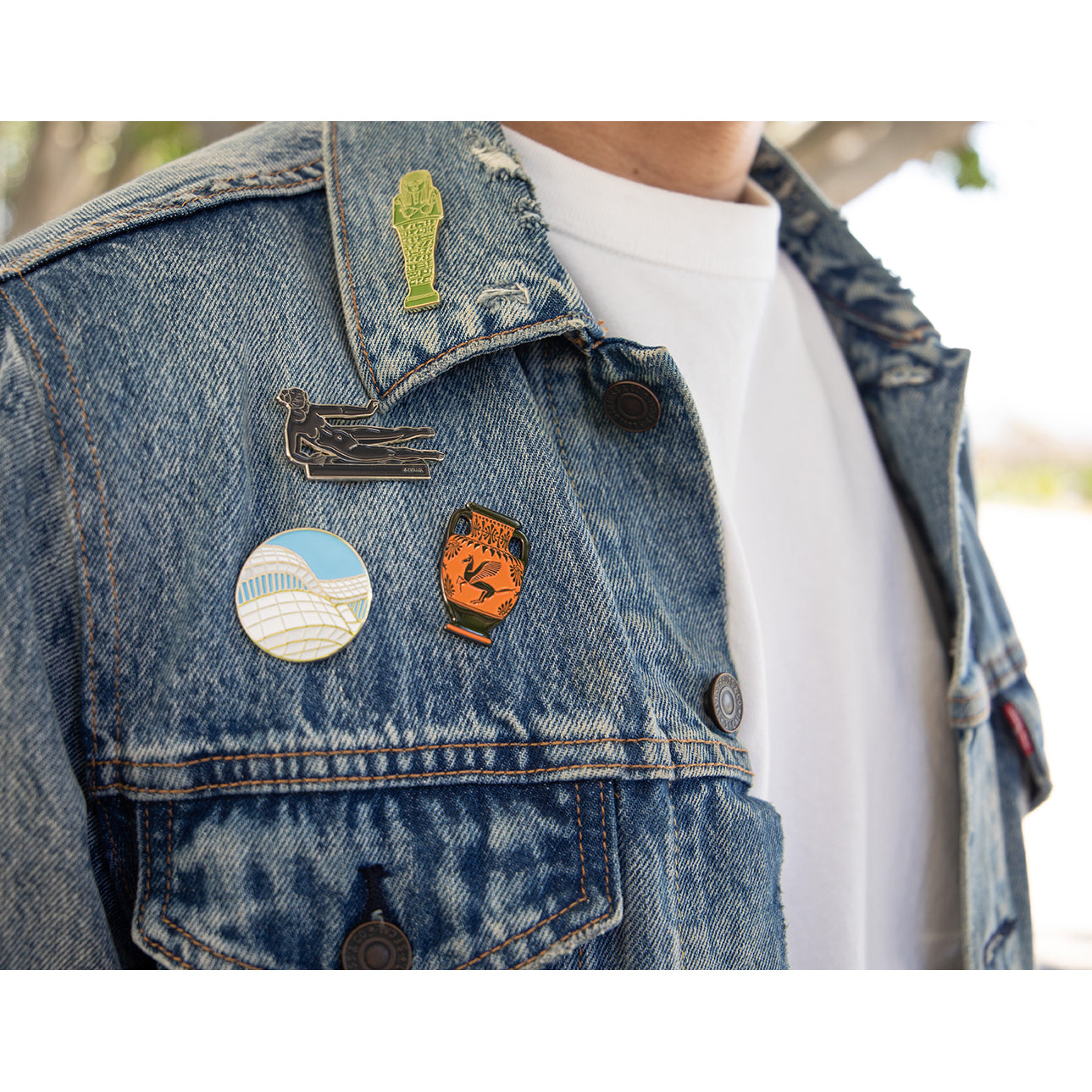 An enamel pin featuring a stylized representation of the Getty Center's architecture with blue sky and white building lines.