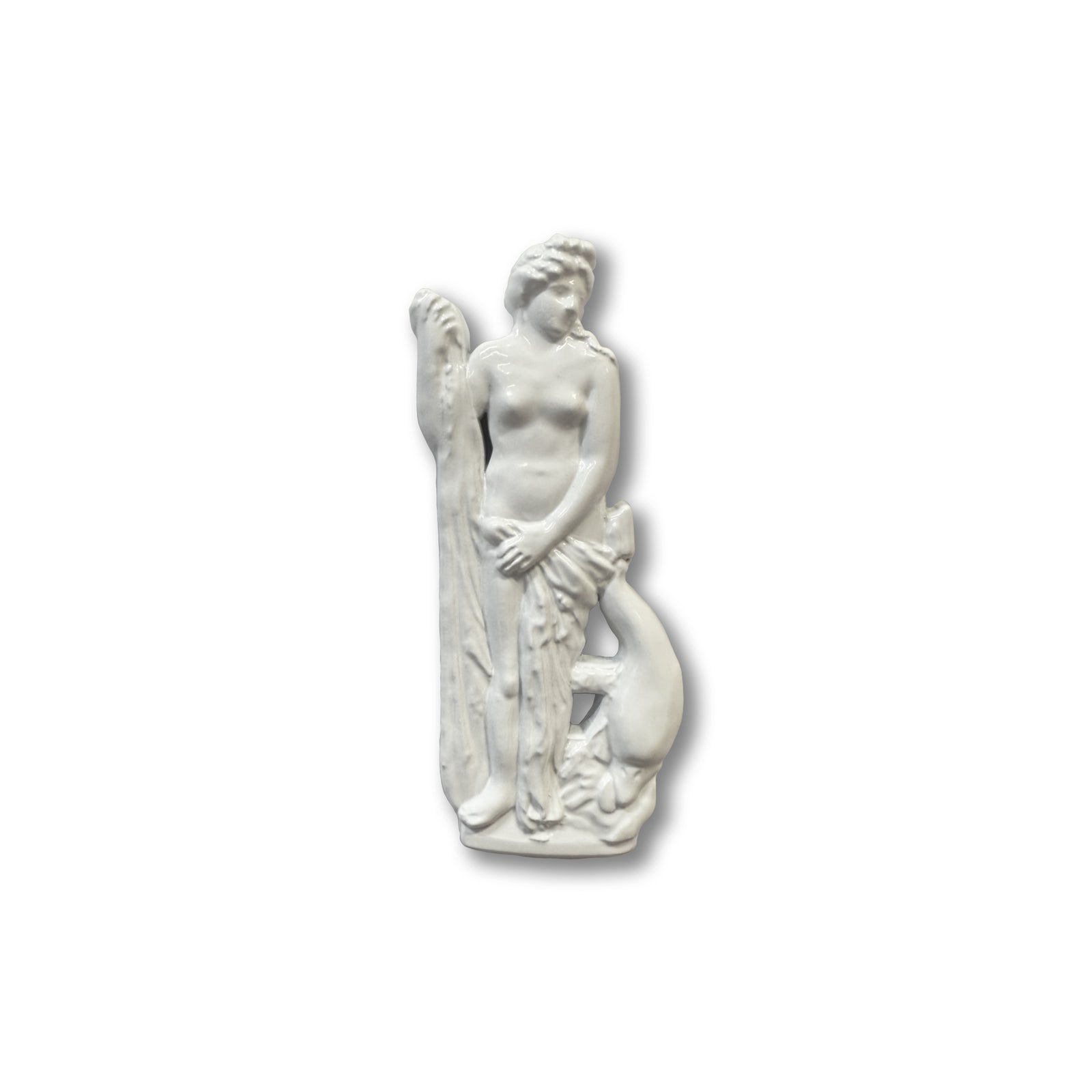 A white pin shaped like a statue of Venus, goddess of love, standing nude and holding a cloth at her hips, with a dolphin at her feet.