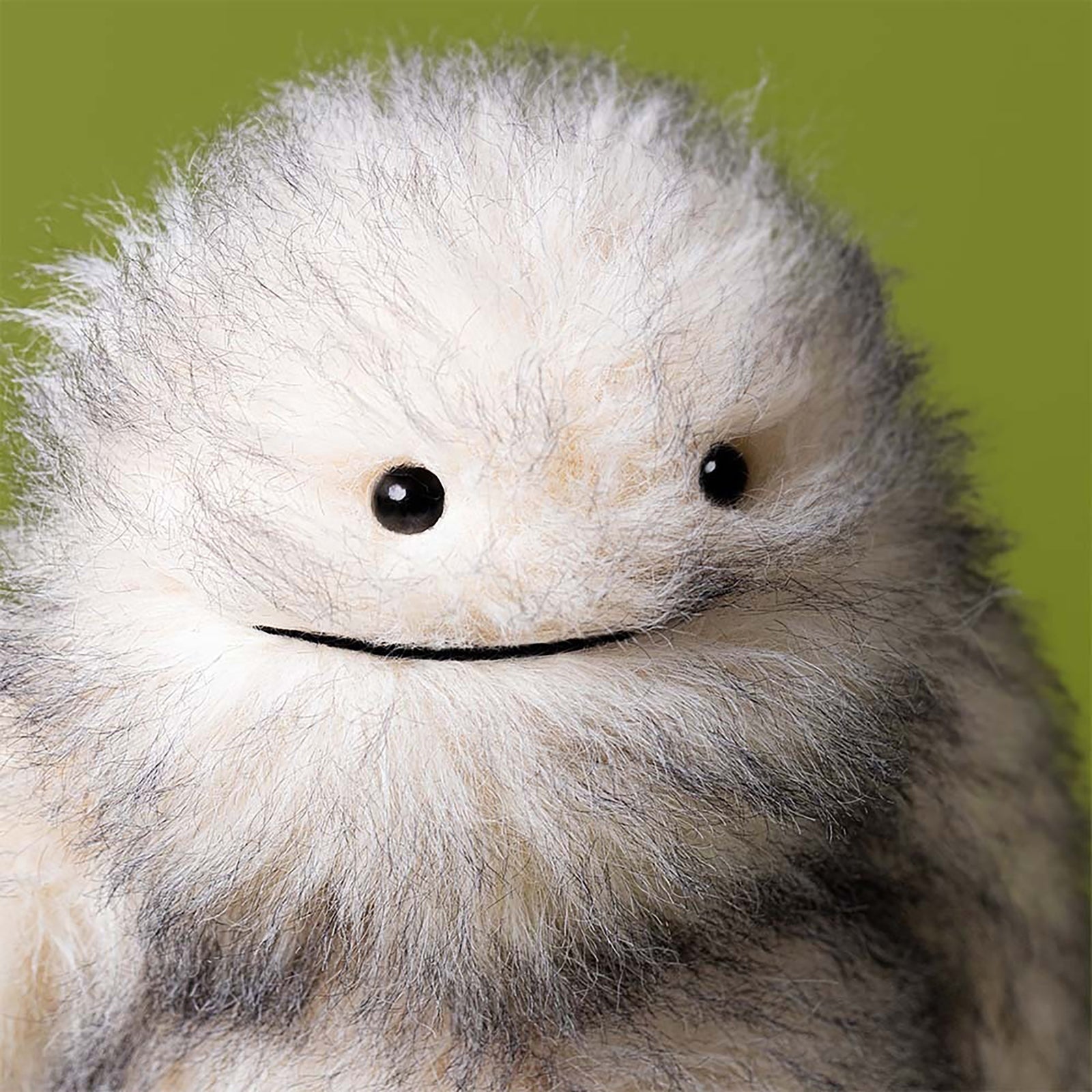 Plush toy resembling a fluffy creature on a white background