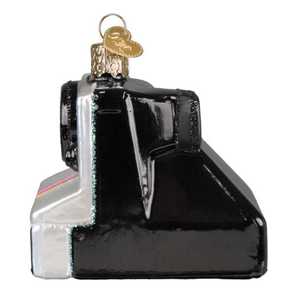 Glass ornament shaped like a black and silver camera on a white background