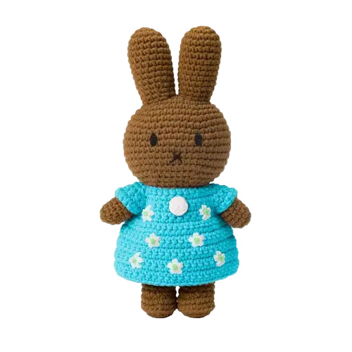 Crocheted rabbit toy wearing a blue dress with white flowers on a white background