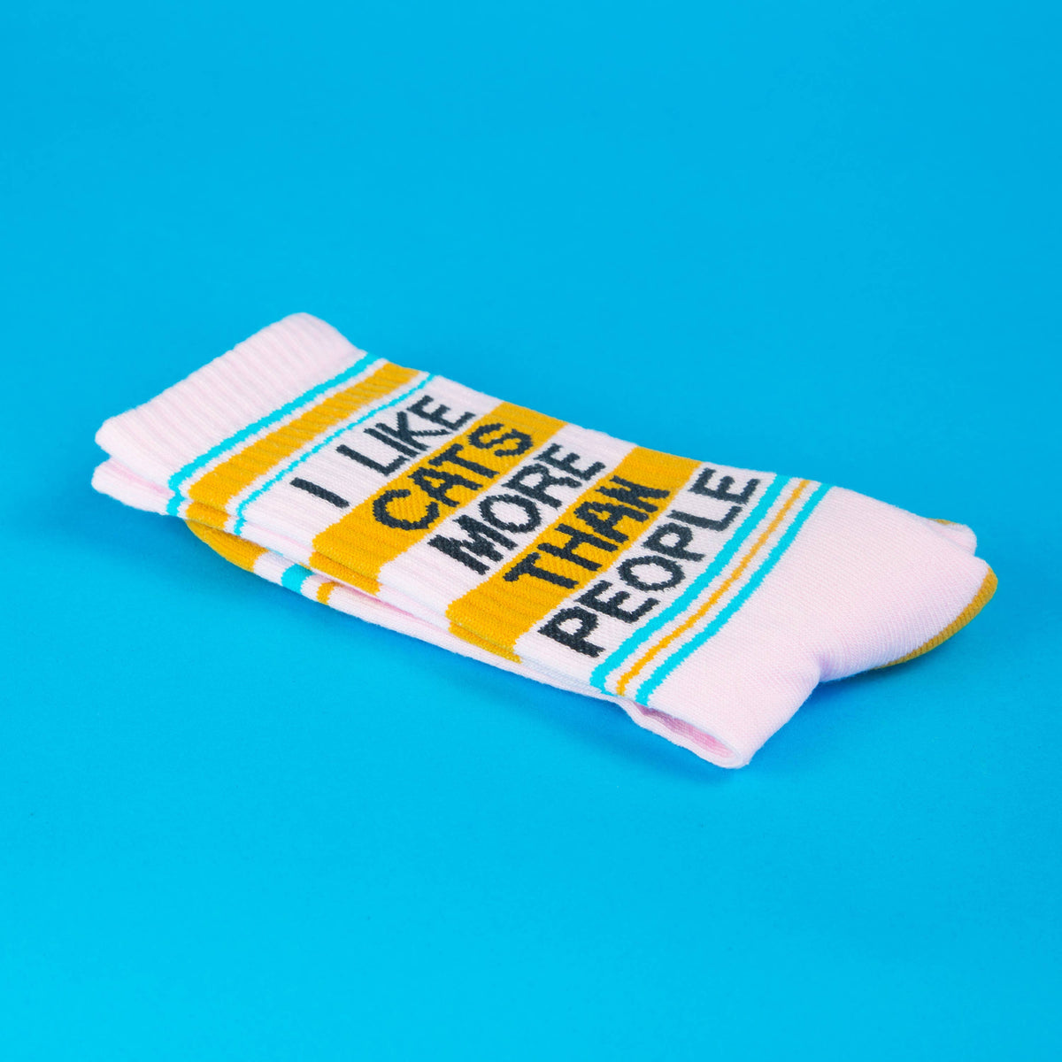 Stack of socks with text 'I like cats more than people' on a blue background