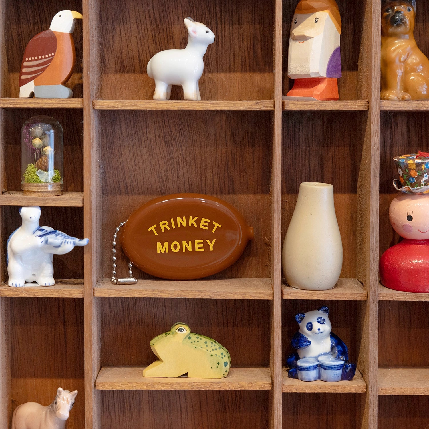 Brown coin purse with 'TRINKET MONEY' text on a white background