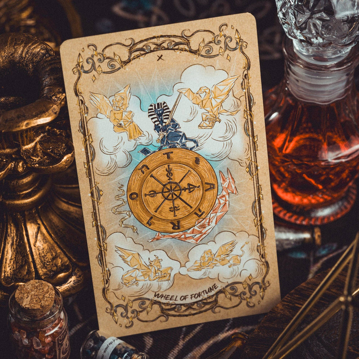 Tarot card with a wheel of fortune design on a mystical background with a bottle and candle.