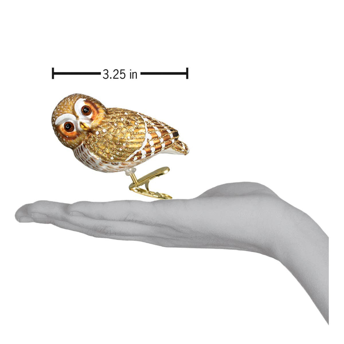 Gold owl figurine held in a hand with measurement label