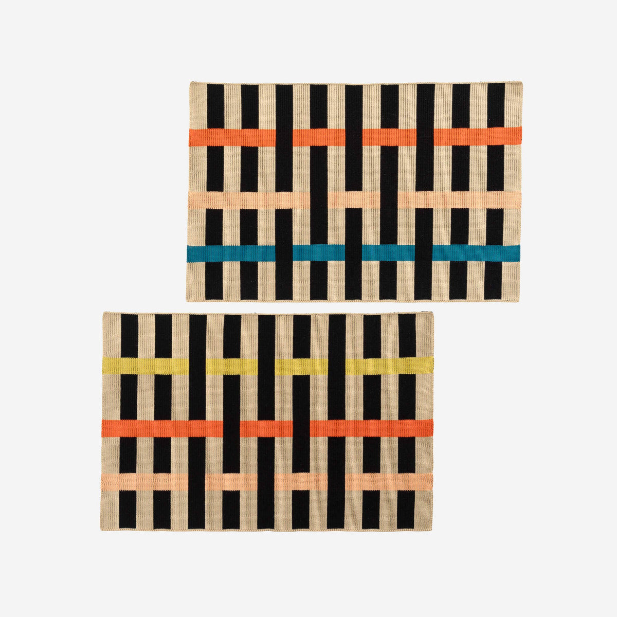 Two rectangular woven rugs with a geometric basketweave pattern in black, beige, orange, teal, and yellow, displayed on a light gray background.