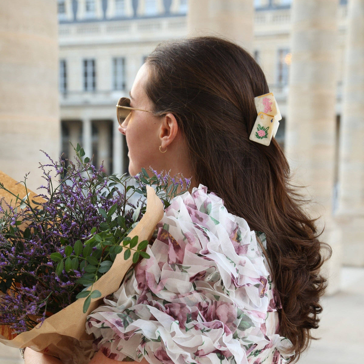 Woman holding a bouquet of flowers with a building in the background