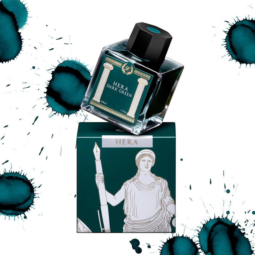 Hera dark green ink bottle and box with ink splashes on a white background