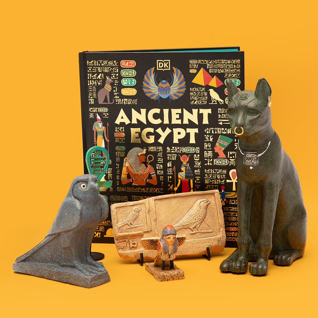 Educational book on Ancient Egypt with cat figurine, hieroglyphics, and other artifacts on a yellow background
