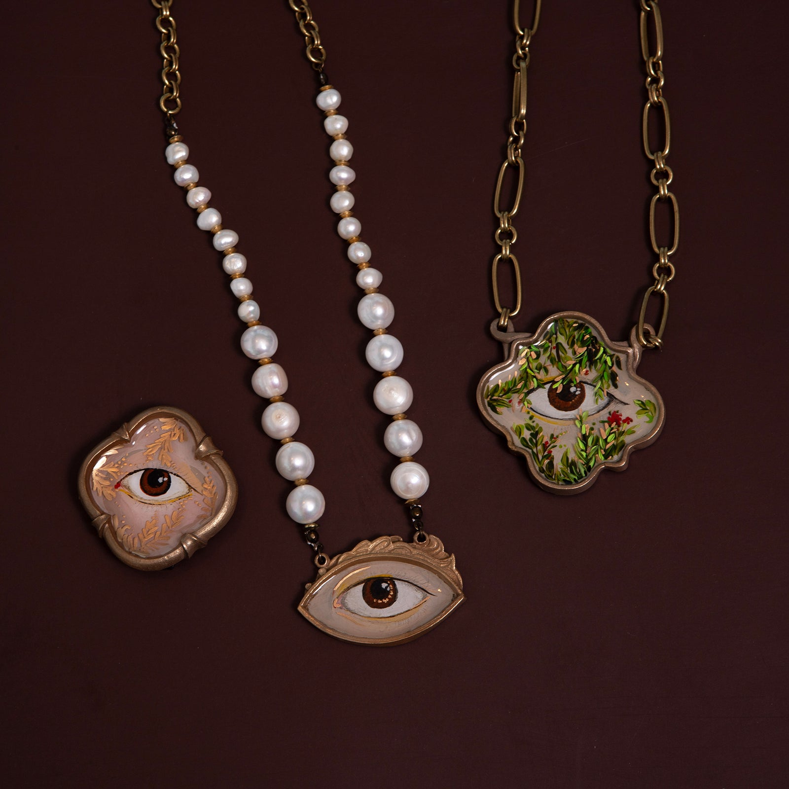 Decorative brooch with eye design on a white background