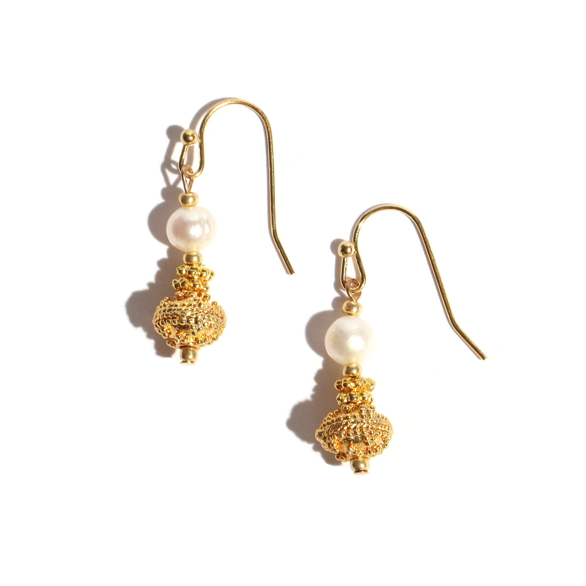 Gold earrings with pearl beads on a white background